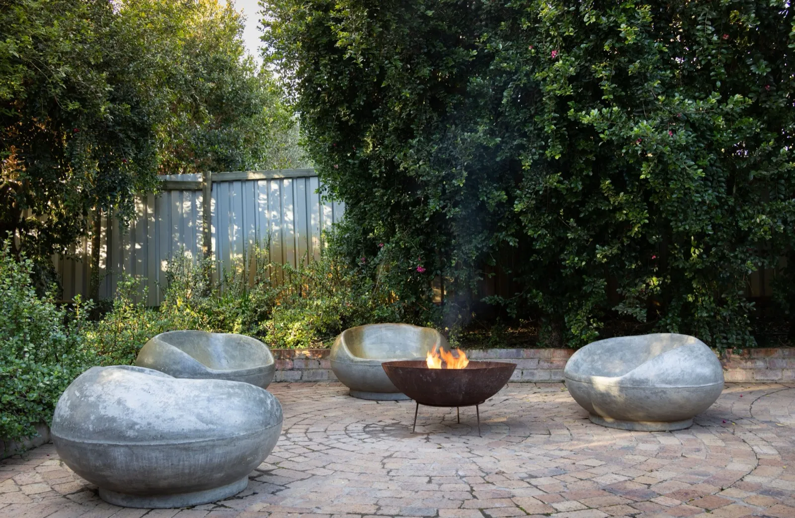 Stone outdoor fireplace with seating for a luxury backyard